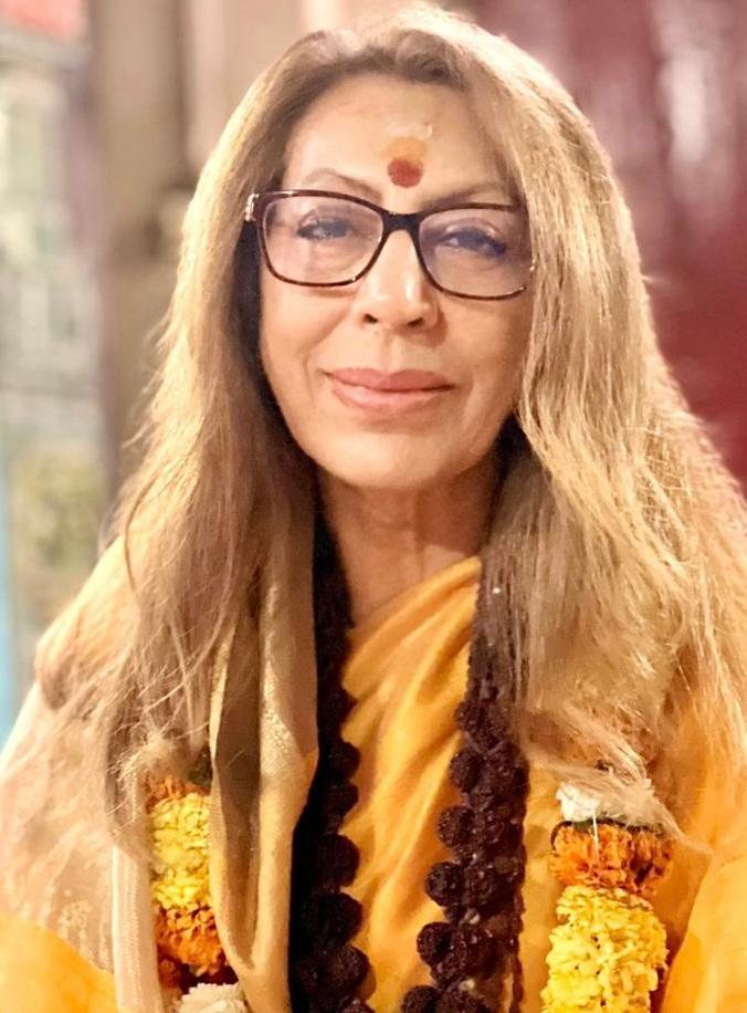 Portrait of Mira Sai wearing a saffron shawl and marigold garland